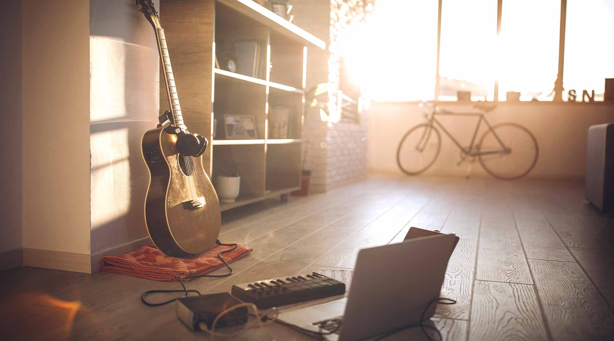 A room with a laptop and guitar.