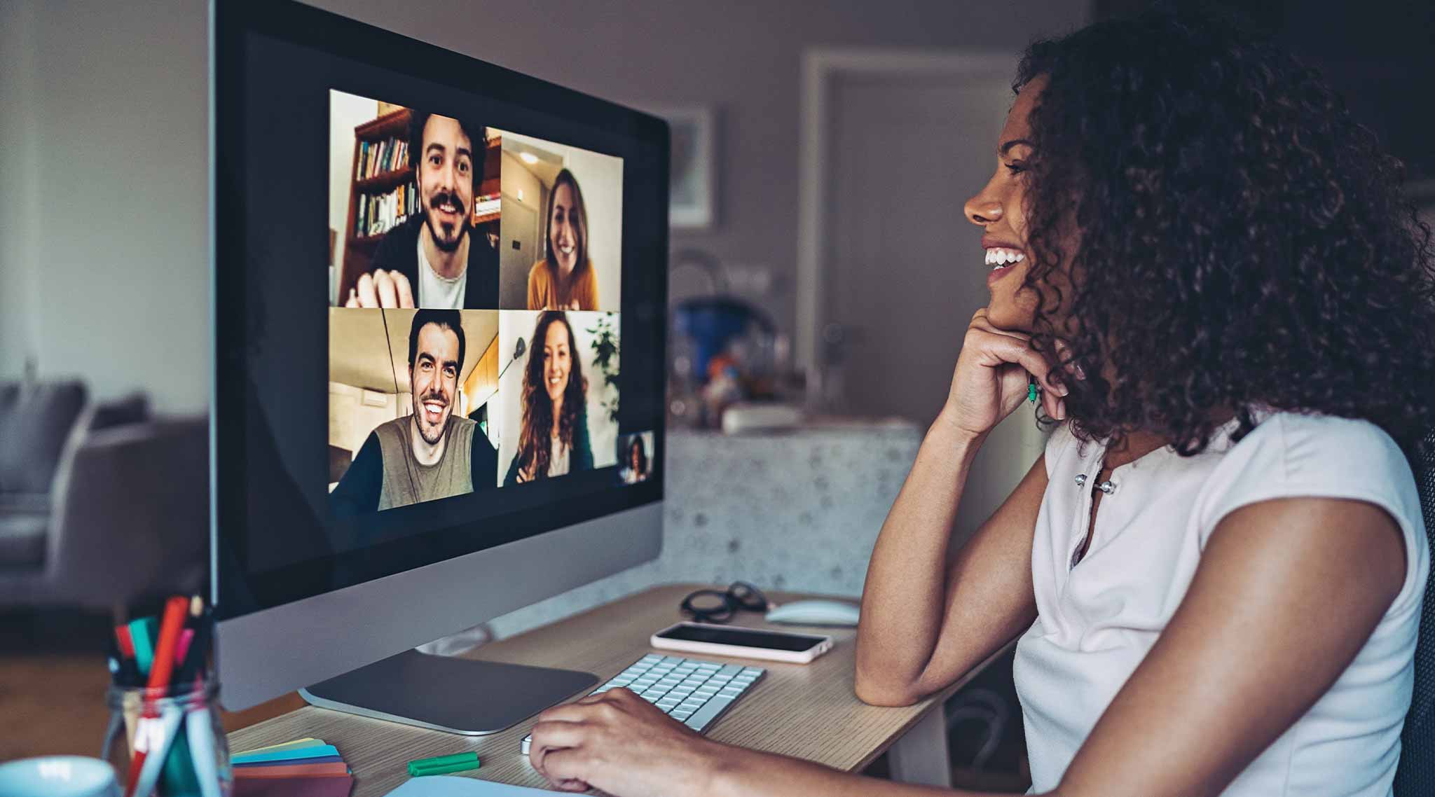 Strategic communication professional speaking to colleagues on desktop computer.