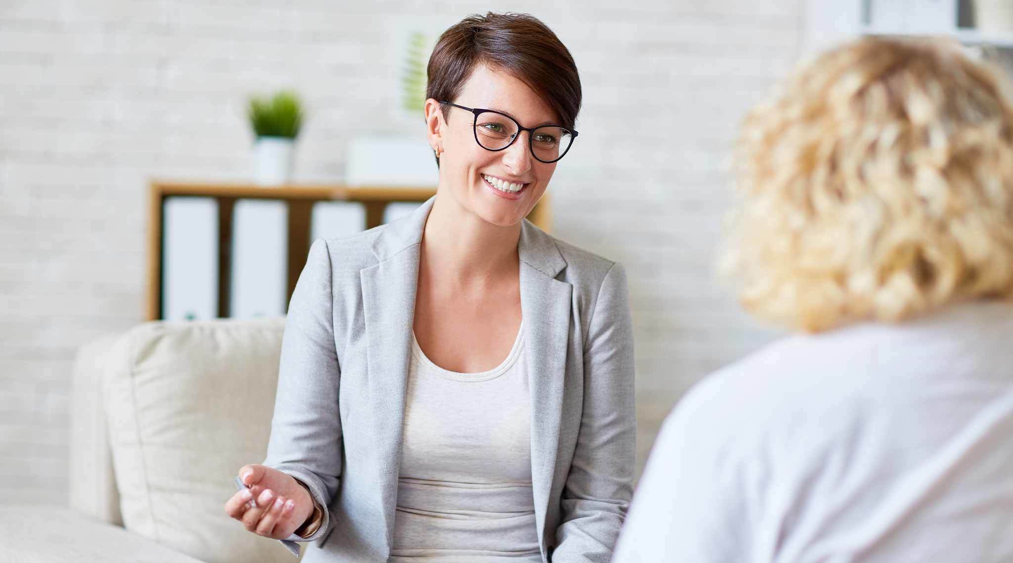 Women interviewing another person in an white modern office setting.