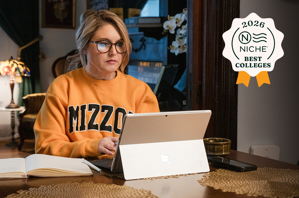 A woman in a Mizzou sweater working on a laptop. The 2026 Niche best colleges ranking badge is in the upper right corner