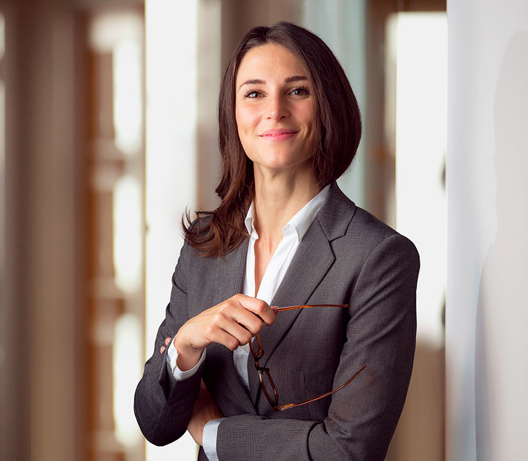 A lawyer smiling and holding their glasses
