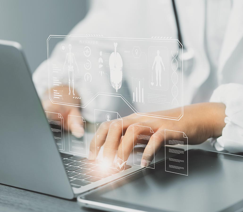 Medical professional looking at informatics on a laptop