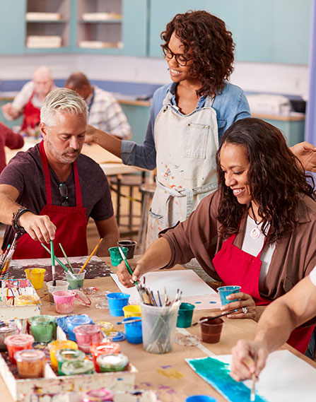 teacher surveying her students paint.