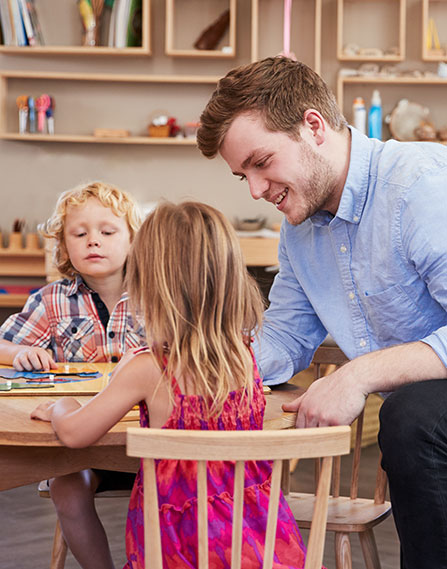 Teacher sitting at a table with students