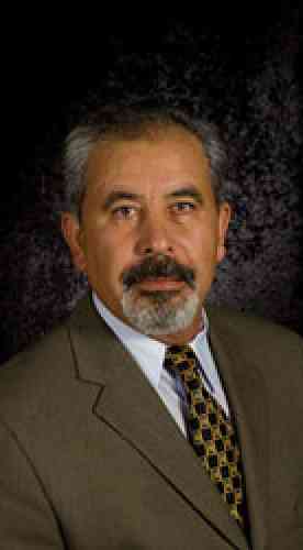 Photo of Moses Hdeib: a middle-eastern man with dark and gray hair and goatee, wearing a suit and tie