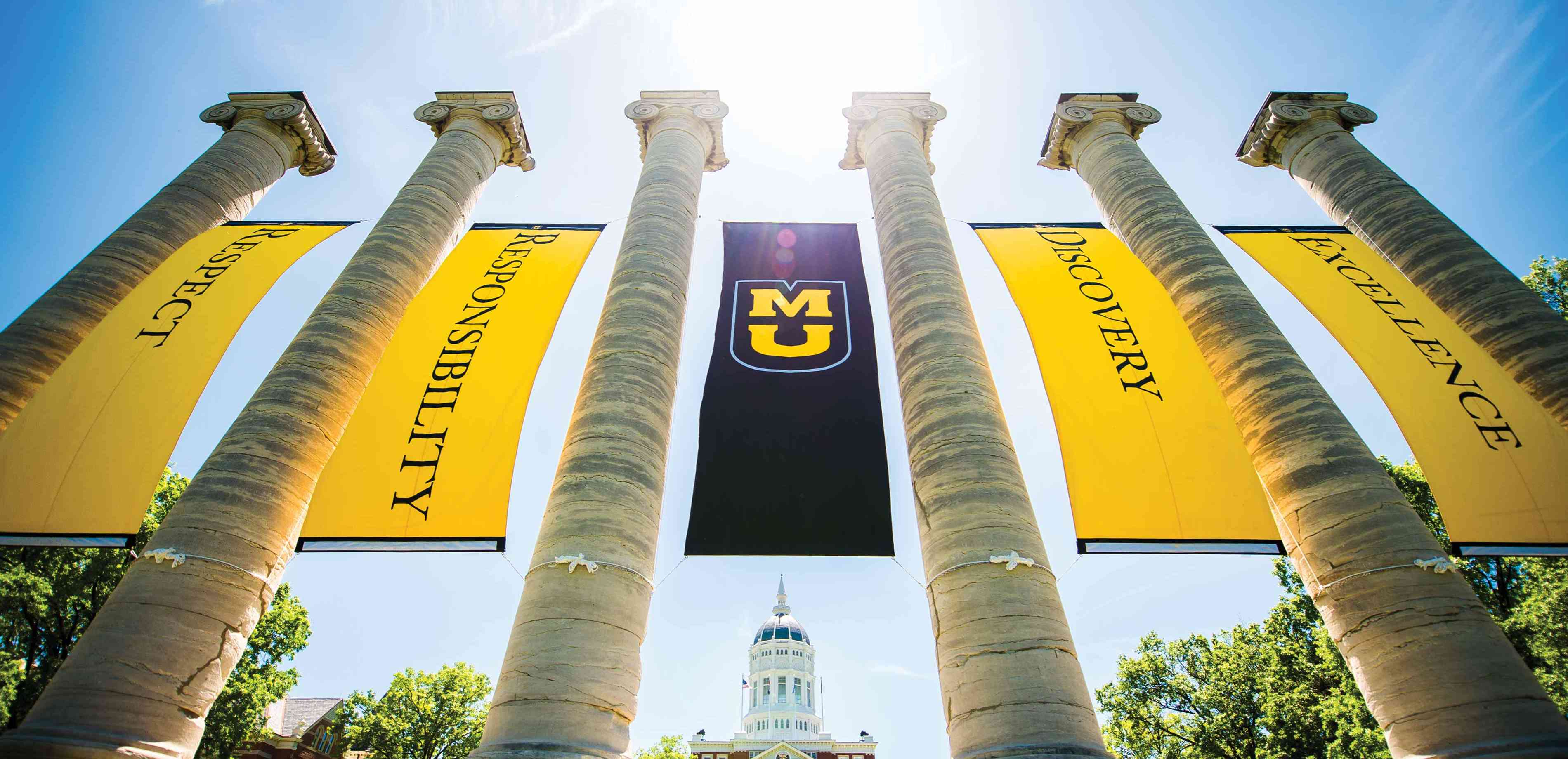 Columns on the Quad on Mizzou's campus, with Jesse Hall in the background.