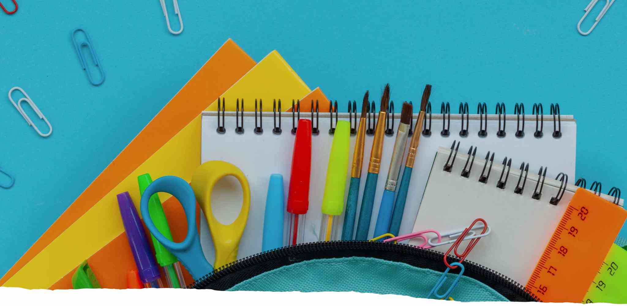 School supplies spilling out of a backpack, such as scissors, paperclips, pens, paintbrushes and a notebook.