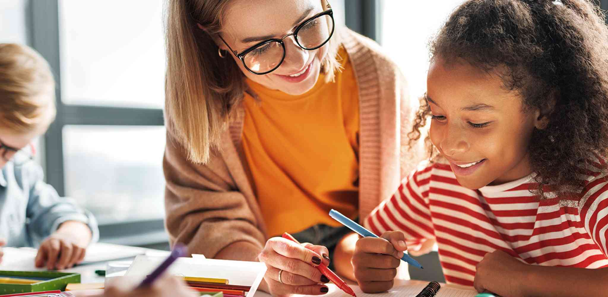 Teacher working in classroom with a student.