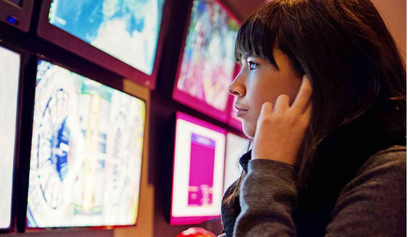 Women looking at an array of computer screens displaying cctv footage of an industrial work environment.