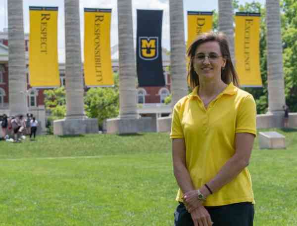 Paula Schuerer, biomedical sciences MS, stands on the Mizzou quad in front of the columns.