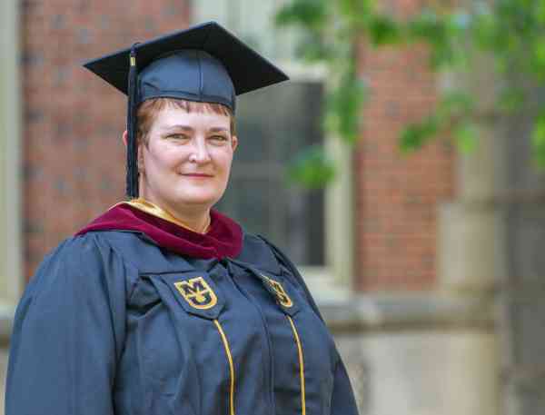 Penny Kittle, master's in youth development, wearing graduation cap and gown.