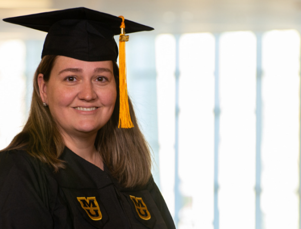 Jennifer Krtek, BSN, wearing her graduation cap and gown.