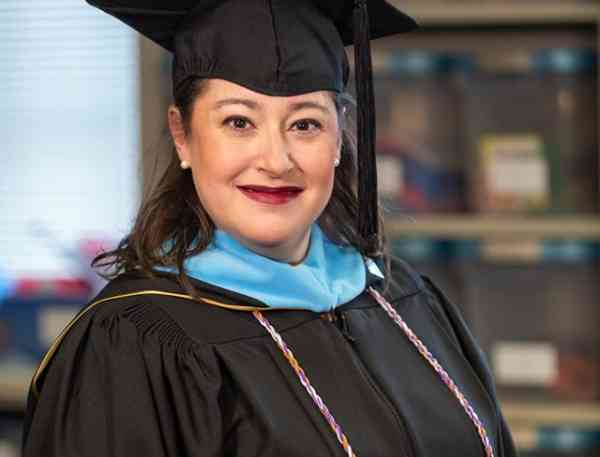 Amy Simons, Mizzou journalism professor and graduate, wearing her graduation cap and gown.
