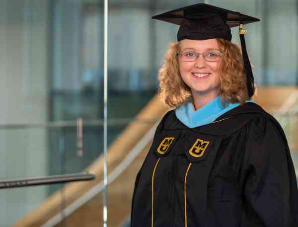 Paige Braun, M Ed, wearing her graduation cap and gown.