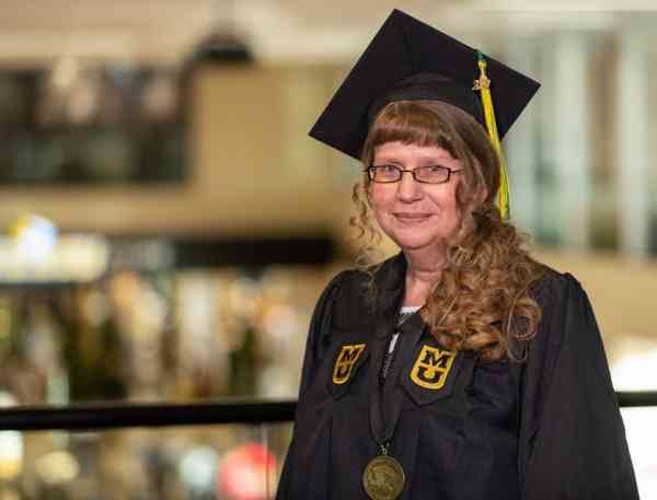 Jennifer Logiudice, radiologic science BHS, wearing her graduation cap and gown at Mizzou's student center.