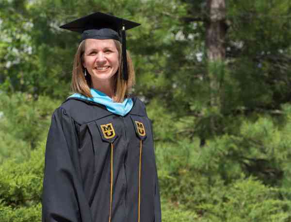 Cori Jett, literacy M Ed, wearing her graduation cap and gown.