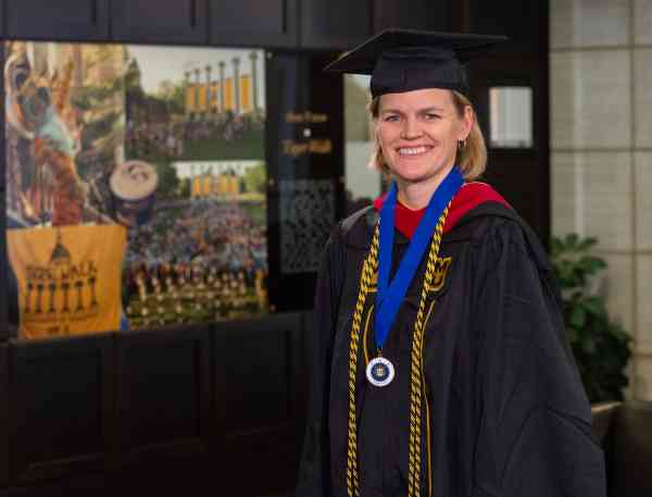 Lisa Brown, MA in journalism with an emphasis in interactive media, wears her graduation cap and gown.