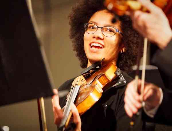 A young person playing the violin.