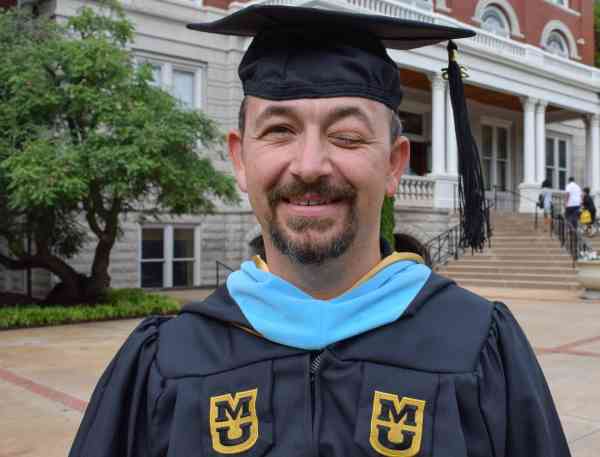 Graduate Brett Greble in his graduation cap and gown.