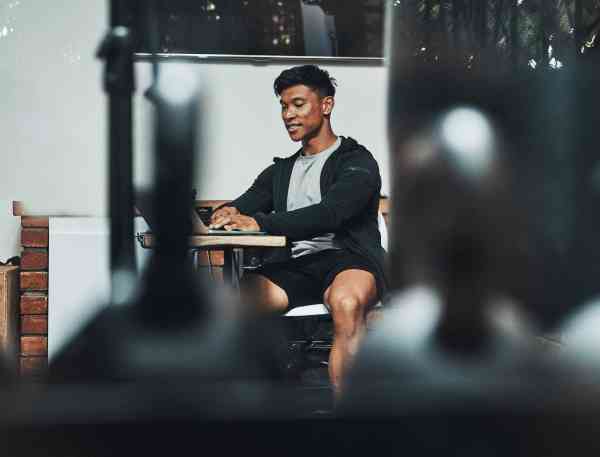 Man in guy sitting at table working on a laptop