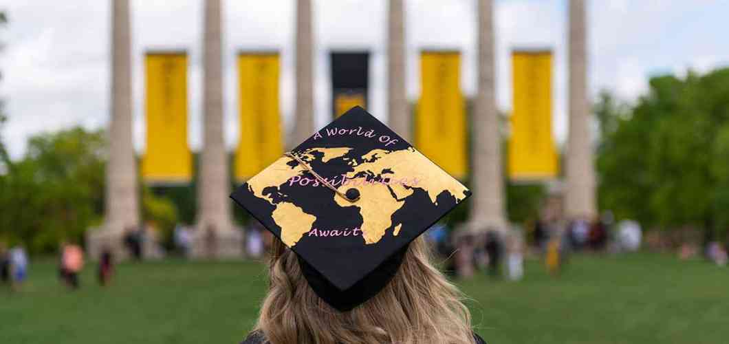 Sarah Swoboda, bachelor's in business administration ’19, faces the columns on Mizzou's campus at commencement; her graduation cap reads A world of endless possibilities.