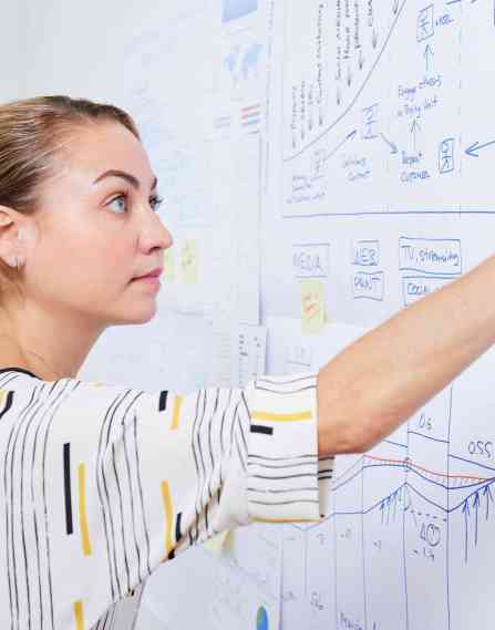 Marketing analytics professional writing on a whiteboard.