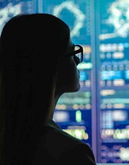 Data scientist in front of screens with charts and graphs.