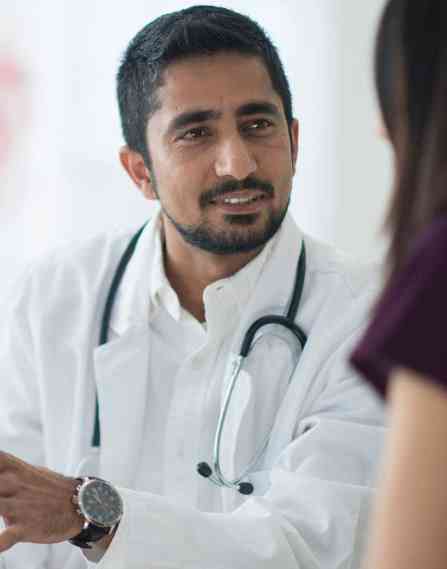 Medical professionals discussing over a tablet.