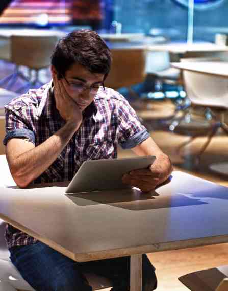 Interactive media professional sitting at table and working on laptop.