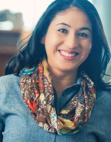Librarian smiling in a library.