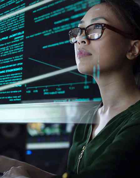 Computer scientist typing at a desktop computer.