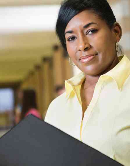 Educational professional standing in a school hallway.