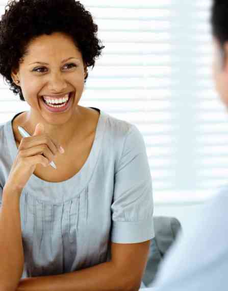 A black female laughs with a colleague