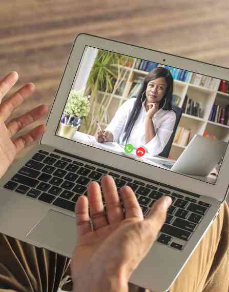 A patient talking to a psychologist on a laptop.