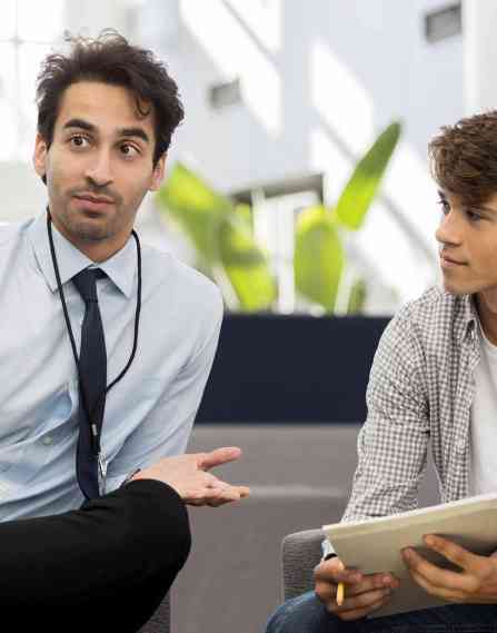 A professional man having a discussion with two young students
