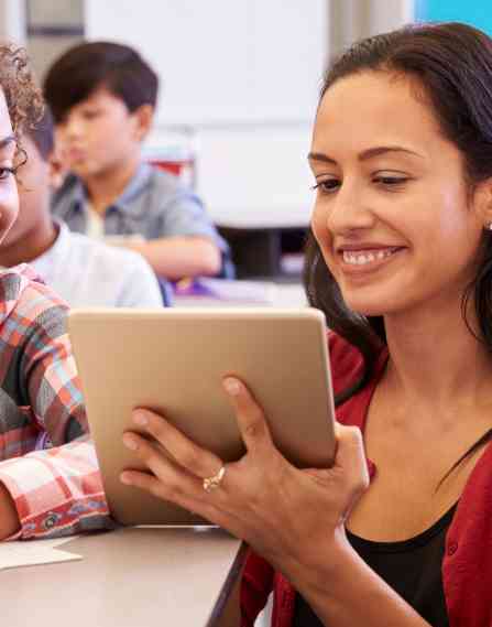 Teacher showing a student something on a tablet.