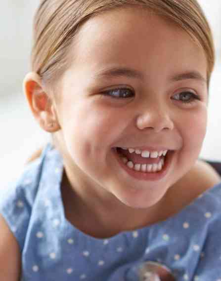Young child smiling at a nurse.