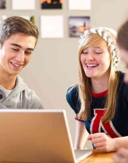 A group of youth working on a laptop.