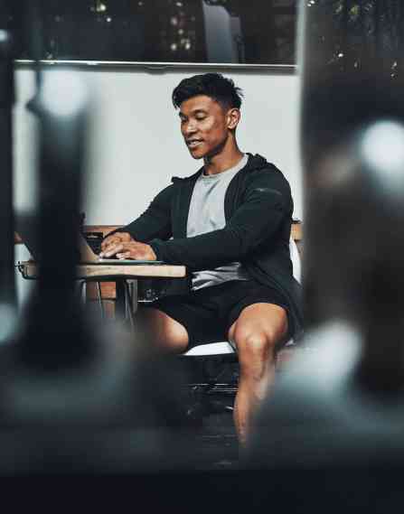Man in guy sitting at table working on a laptop