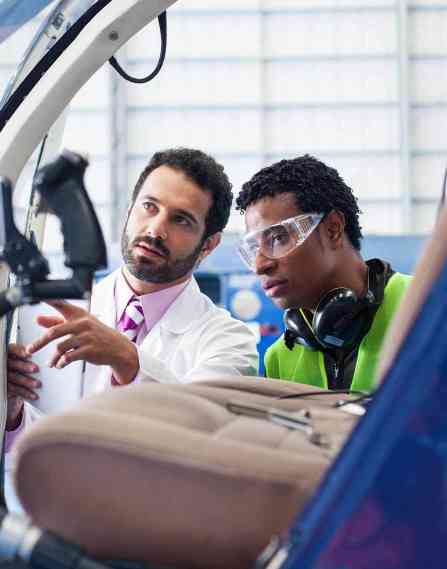 Engineer gives instructions to the technician about the work that should be done to a helicopter.
