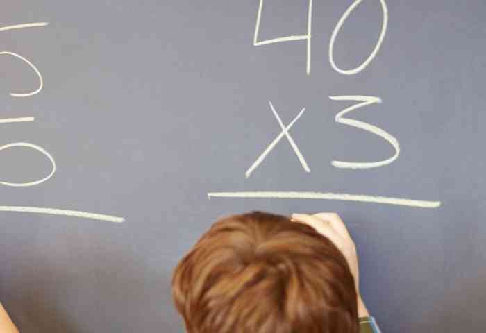 young children solving arithmetic on a blackboard  