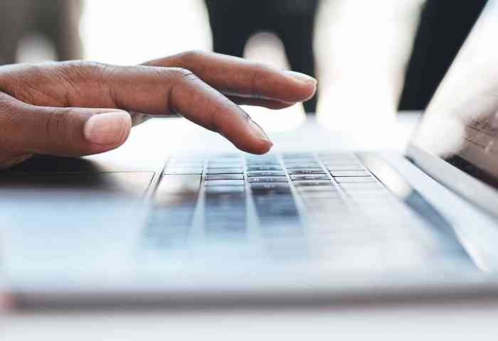 Hands typing on a laptop.