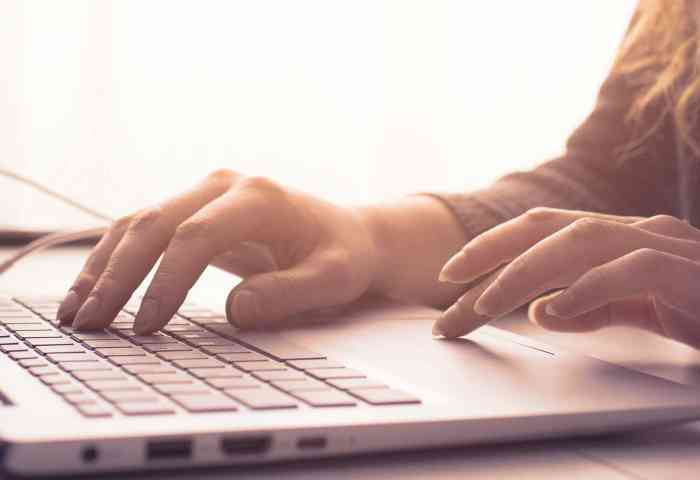 Hands typing on a laptop.