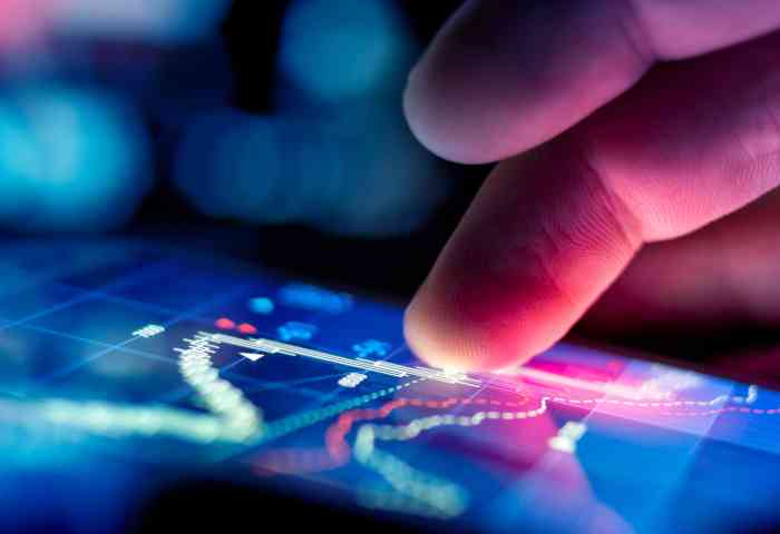 Zoomed in on two fingers using a touchscreen with abstract technology graph.