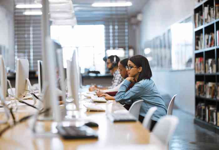 Shot of a group of university students working on computers in the library at campus