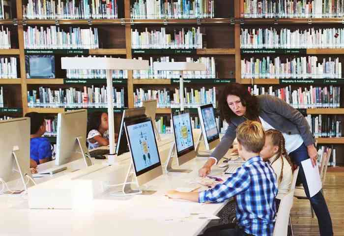 A librarian assisting a patron on the computer.