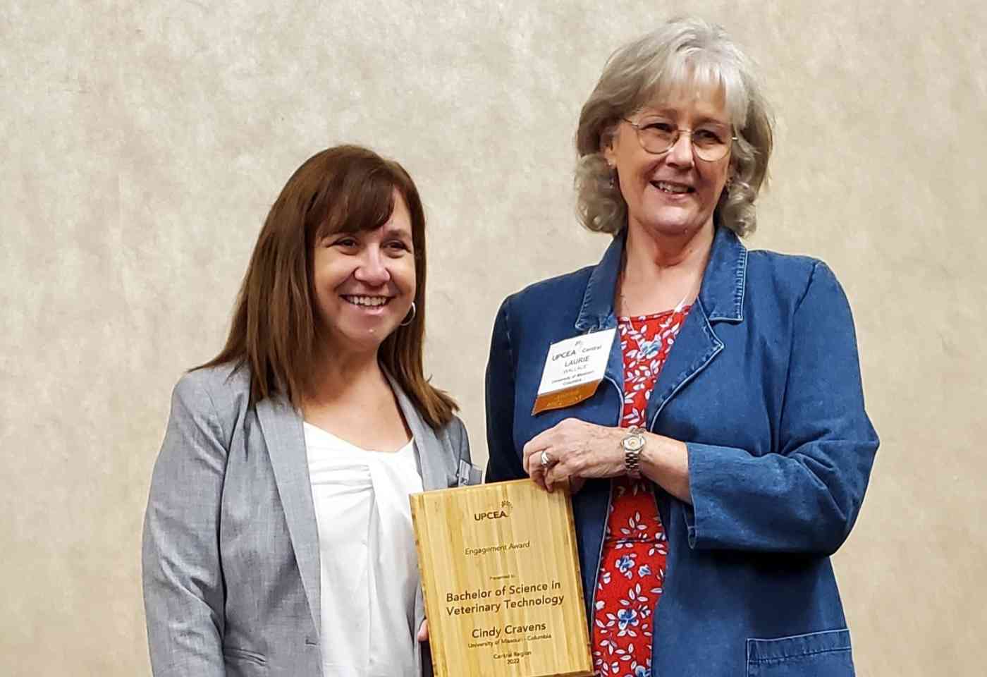 Laurie Wallace, director of veterinary programs and associate teaching professor accepts the award from UPCEA Board President, Lisa Templeton.
