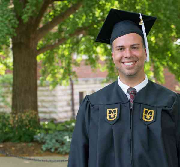 Nelson Perez, BGS, wearing his cap and gown on Mizzou's campus.