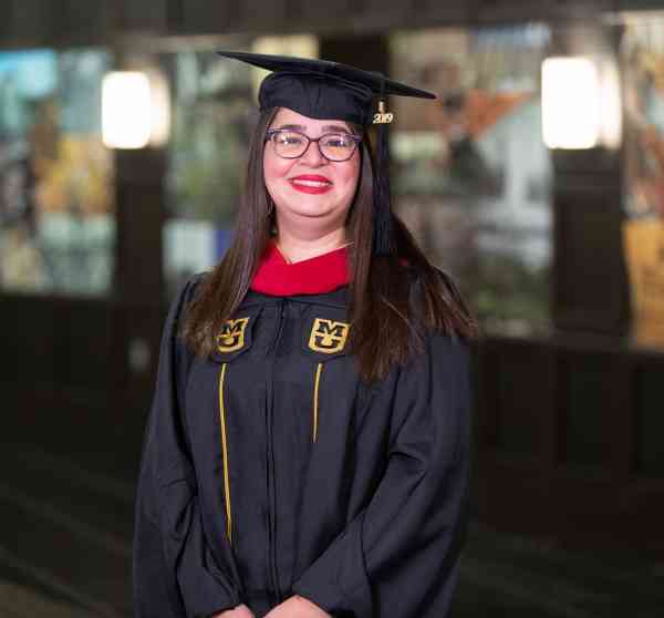 Anna Politano, MA in journalism, media management, wearing her graduation cap and gown at the Mizzou student center.
