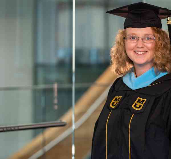 Paige Braun, M Ed, wearing her graduation cap and gown.